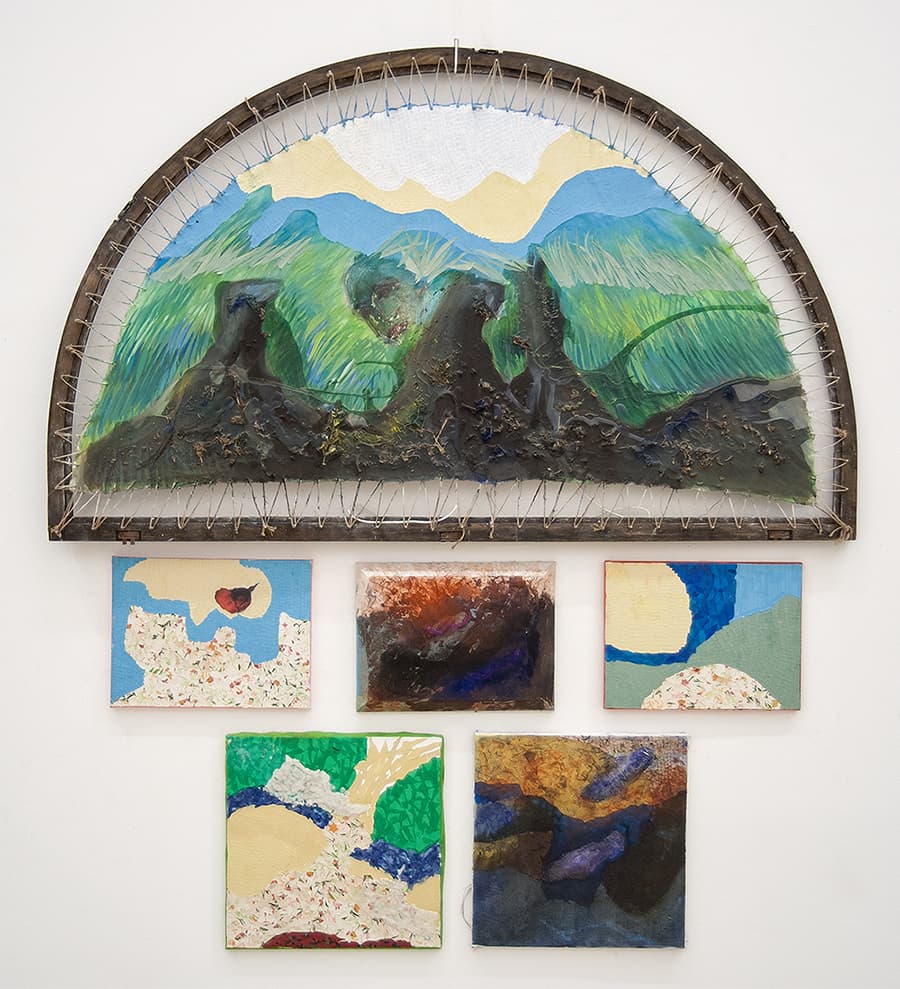 A collection of paintings adorns a wall, creating an artistic display.
