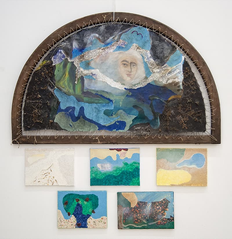 A collection of paintings adorns a wall, creating an artistic display.